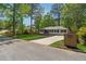 A beautifully landscaped home with green grass, dark mulch, a fence, and a newly paved driveway at 1737 Briarlake Cir, Decatur, GA 30033