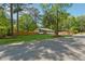 A well-maintained home showcasing lush green grass and mature trees surrounding a fully fenced property at 1737 Briarlake Cir, Decatur, GA 30033