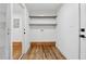 Bright laundry room with hardwood floors, floating shelves, and utility connections at 1737 Briarlake Cir, Decatur, GA 30033