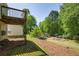 Lush backyard with mature trees, a wooden deck and a community playground for outdoor fun and relaxation at 3140 Ennfield Ln, Duluth, GA 30096