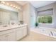 Bright bathroom showcasing double sink vanity, large soaking tub, and natural light at 3140 Ennfield Ln, Duluth, GA 30096