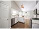 Well-lit kitchen features white cabinets, stainless steel appliances, and dark hardwood floors at 3140 Ennfield Ln, Duluth, GA 30096