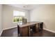 Bright home office with a large desk, dark wood floors, and a window for natural light at 3140 Ennfield Ln, Duluth, GA 30096