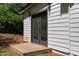 A backyard studio featuring double doors, a small deck, and white siding at 7171 Hazelwood Dr, Jonesboro, GA 30236