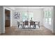 Dining room features a modern light fixture, multiple windows with natural light, and seating for six around a dark wood table at 7171 Hazelwood Dr, Jonesboro, GA 30236