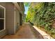 The side patio with brick pavers is lined with an attractive bench and mature landscaping for privacy at 127 Stoney Creek Pkwy, Woodstock, GA 30188