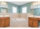 A large soaking tub is nestled between two wood vanity units, creating a spa-like atmosphere at 127 Stoney Creek Pkwy, Woodstock, GA 30188