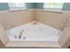 Corner whirlpool bathtub featuring a white tub, chrome fixtures, and tile surround at 127 Stoney Creek Pkwy, Woodstock, GA 30188