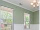 Dining room featuring white wainscoting, light green walls, and natural light from two windows at 127 Stoney Creek Pkwy, Woodstock, GA 30188