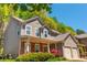 Side view of a two-story home with neutral siding, a brick porch, and an attached two-car garage at 127 Stoney Creek Pkwy, Woodstock, GA 30188