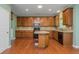 Spacious kitchen featuring wood floors, wood cabinets, an island, and stainless steel appliances at 127 Stoney Creek Pkwy, Woodstock, GA 30188