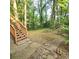The wooden staircase leads out to the spacious backyard that contains lush greenery at 1901 Arnold Dr, Austell, GA 30106