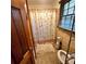 Cozy bathroom featuring tile flooring, a decorative shower curtain and a view of the backyard at 1901 Arnold Dr, Austell, GA 30106