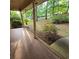Covered front porch with tile flooring and a serene view of the lush, green landscape at 1901 Arnold Dr, Austell, GA 30106