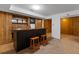 Finished basement featuring a bar area with wood paneling and two stools for entertaining guests at 350 Covered Bridge Sw Pl, Smyrna, GA 30082