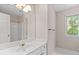 Bright bathroom showcasing a wide mirror, vanity with white countertops, and a window for natural light at 350 Covered Bridge Sw Pl, Smyrna, GA 30082