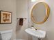 Classic half bathroom with a pedestal sink, round mirror, and decorative art at 350 Covered Bridge Sw Pl, Smyrna, GA 30082