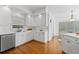 Bright kitchen features white cabinets, stainless steel appliances, and beautiful hardwood floors at 350 Covered Bridge Sw Pl, Smyrna, GA 30082