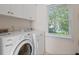 Functional laundry room with washer, dryer, and window for natural light at 350 Covered Bridge Sw Pl, Smyrna, GA 30082