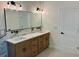 Bathroom with double sinks, marble countertops, wood cabinets and black hardware at 409 Saint Surrey Way, Ellenwood, GA 30294