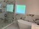 Bathroom with a glass enclosed shower, soaking tub, and marbled tile at 409 Saint Surrey Way, Ellenwood, GA 30294