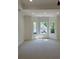 Spacious bedroom with a bay window, tan walls, tan carpet, and white trim at 409 Saint Surrey Way, Ellenwood, GA 30294
