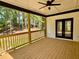Inviting outdoor wooden deck with ceiling fan, dark trim and a picturesque view of the surrounding trees at 409 Saint Surrey Way, Ellenwood, GA 30294