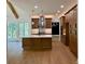 A modern kitchen with stainless steel appliances, an island with a marble countertop and wood cabinets at 409 Saint Surrey Way, Ellenwood, GA 30294