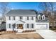 Charming two-story white brick home featuring a well-manicured front lawn and a cozy, covered entryway at 4100 Devon Wood Ne Dr, Marietta, GA 30066