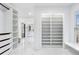 This walk-in closet features custom shelving and drawer units, leading to a spa-like bathroom at 4100 Devon Wood Ne Dr, Marietta, GA 30066