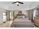Bright primary bedroom features tray ceilings, ceiling fan, hardwood floors, and a large window at 829 Verdun Way, Marietta, GA 30064
