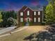 Charming two-story brick home with manicured lawn and inviting curb appeal at dusk at 829 Verdun Way, Marietta, GA 30064