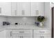 Kitchen counter with decor and white cabinets with marble backsplash at 829 Verdun Way, Marietta, GA 30064