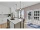 Bright kitchen with stainless steel appliances, kitchen island with sink, and sliding glass doors to outdoor deck at 829 Verdun Way, Marietta, GA 30064
