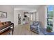 Bright living room with hardwood floors, piano, staircase, and entry to a bathroom at 829 Verdun Way, Marietta, GA 30064