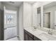 Bathroom with double sink vanity, granite countertops, two mirrors and open doorway at 1280 Firefly Field Trce, Lawrenceville, GA 30045