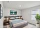 This is a staged bedroom with a grey bedframe, two side tables, and an attractive accent wall hanging at 1280 Firefly Field Trce, Lawrenceville, GA 30045