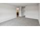 A spacious, carpeted bedroom with a view into the bathroom features a neutral decor palette at 1280 Firefly Field Trce, Lawrenceville, GA 30045