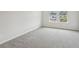 A bright bedroom featuring light gray carpet and white walls is bathed in natural light at 1280 Firefly Field Trce, Lawrenceville, GA 30045