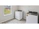 Laundry room with a washer, a dryer, white shelves, a window and wood look floors at 1280 Firefly Field Trce, Lawrenceville, GA 30045