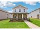 Charming two-story home featuring stone accents, a covered front porch, and a well-maintained lawn at 1290 Firefly Field Trce, Lawrenceville, GA 30045