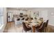 Staged kitchen view featuring bar stools, a dining table set for eight, and a stainless steel refrigerator at 1290 Firefly Field Trce, Lawrenceville, GA 30045