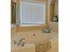 Close-up of garden tub in bathroom with window and decorative towel at 1670 Cooper Lakes Dr, Grayson, GA 30017