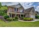 Charming brick two-story home with a covered front porch and beautifully landscaped front yard at 1670 Cooper Lakes Dr, Grayson, GA 30017