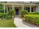 Inviting front entrance with a black door framed by white columns, lush landscaping, and a paved walkway at 1670 Cooper Lakes Dr, Grayson, GA 30017