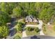 Aerial view of a brick home with well-manicured lawn, circular driveway, and surrounding mature trees at 1750 Providence Place Dr, Alpharetta, GA 30009