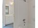 Bathroom featuring white tile, a shower-tub combo, and a view into an adjacent room with a vanity at 1750 Providence Place Dr, Alpharetta, GA 30009