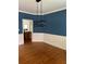 Dining room with blue walls and white wainscoting features hardwood floors and a modern light fixture at 1750 Providence Place Dr, Alpharetta, GA 30009