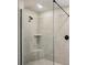 Modern bathroom with grey tiled walls, frameless shower and corner seat at 241 Martin Spring Rd, Lawrenceville, GA 30045
