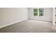 Well-lit carpeted bedroom with neutral walls and trim, and a bright window view at 241 Martin Spring Rd, Lawrenceville, GA 30045